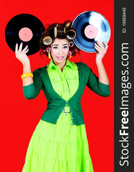 Portrait of a woman with curlers on her hair holding gramophone record. Retro style. Portrait of a woman with curlers on her hair holding gramophone record. Retro style.