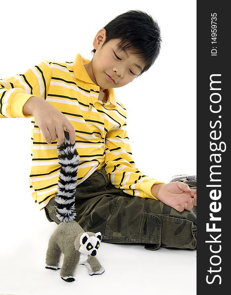 Photo of Asian kid with lemur toy. Photo of Asian kid with lemur toy