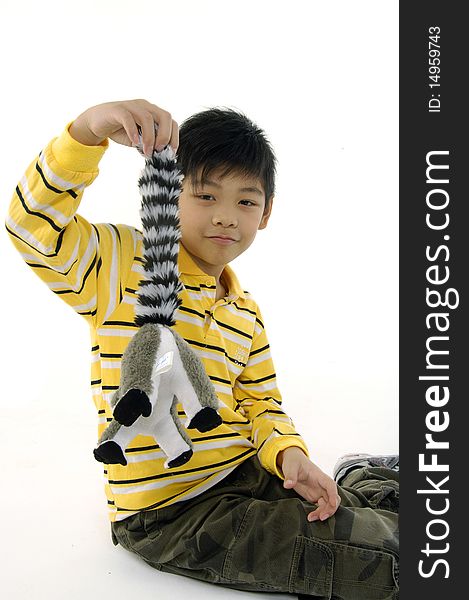 Photo of Asian kid with lemur toy. Photo of Asian kid with lemur toy