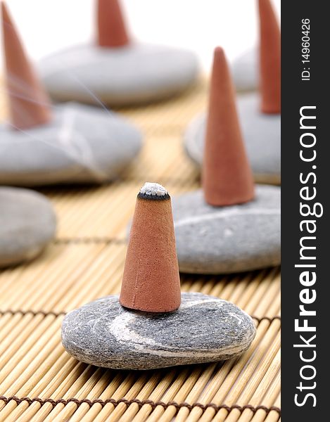 Incense cones and stone on bamboo mat. Incense cones and stone on bamboo mat