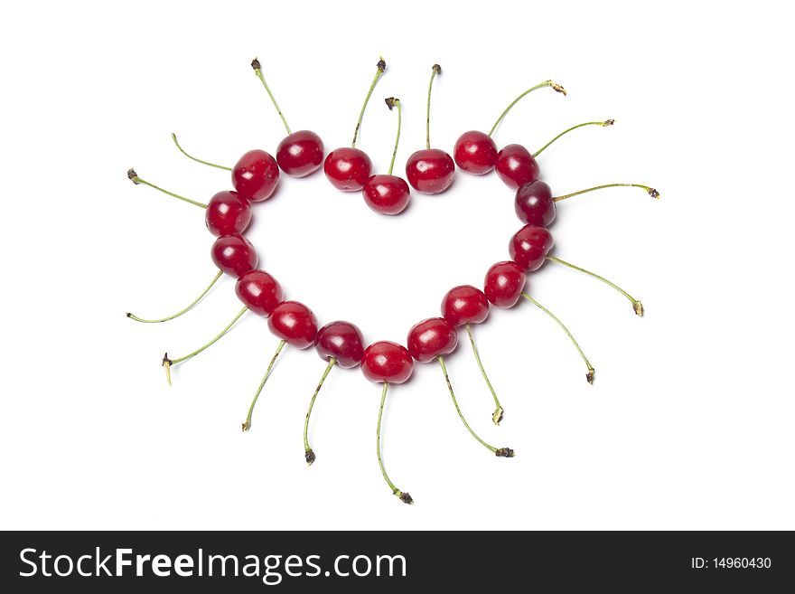 Heart of fresh cherries on a white background