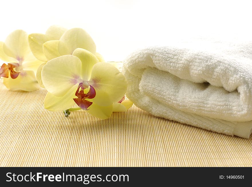 towel and orchids on bamboo mat. towel and orchids on bamboo mat