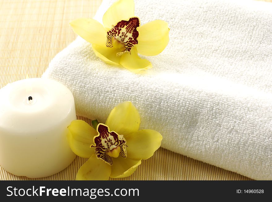 Candle, towel with yellower orchids. Candle, towel with yellower orchids