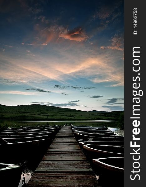 Boats on the lake besides a pontoon bridge with a beautiful sky. Boats on the lake besides a pontoon bridge with a beautiful sky