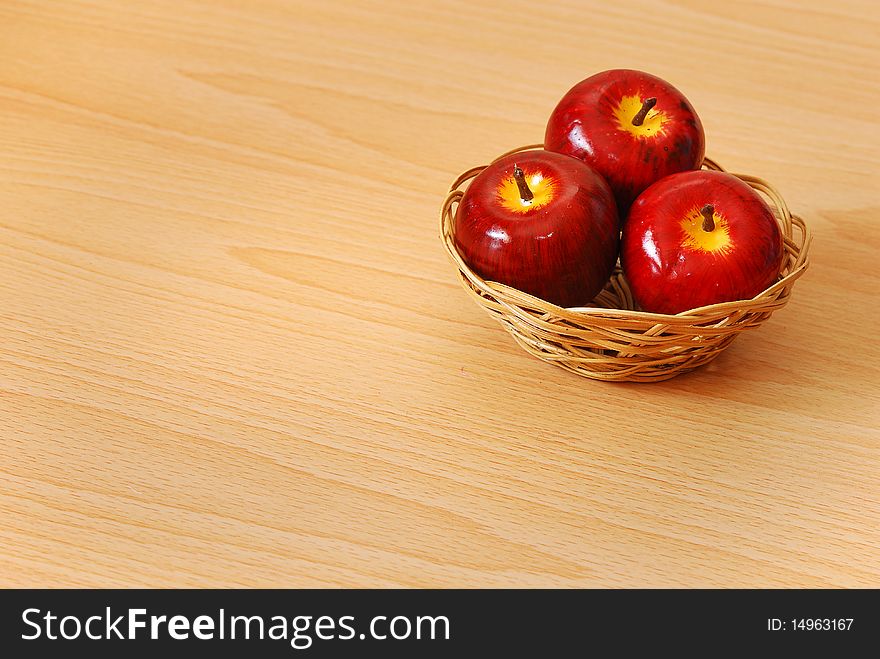 A basket with three red apples. A basket with three red apples