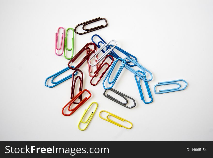 Many colored paper clips isolated on white