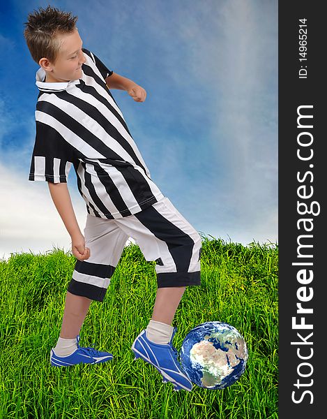 Young footballer with on grass with ball in shape of Earth. Young footballer with on grass with ball in shape of Earth