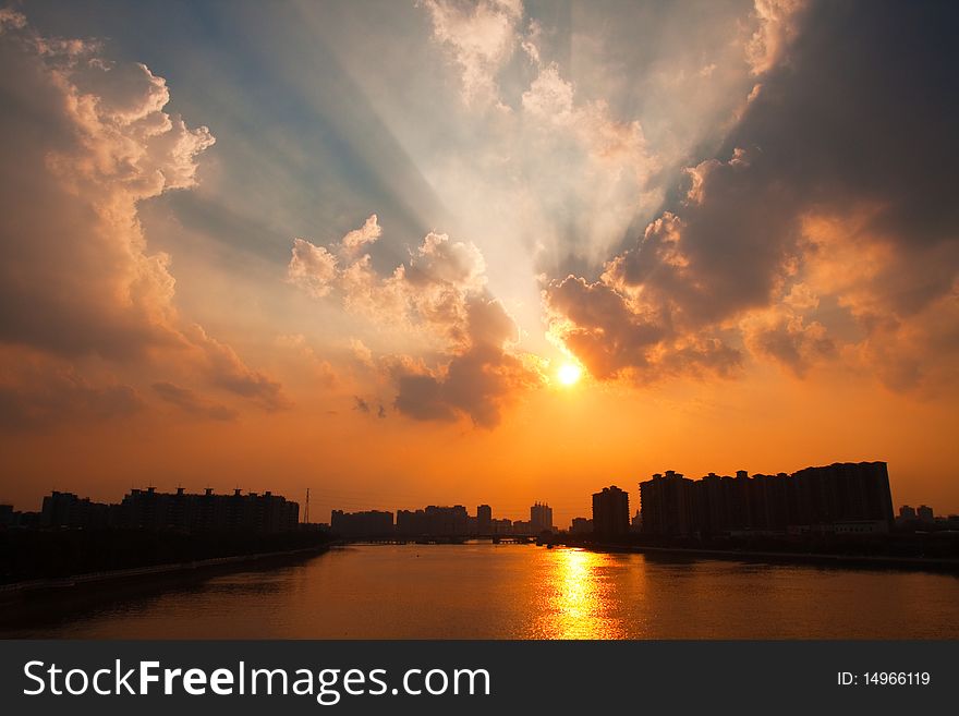 Sun just move out of the clouds and rays come out from the edge of the clouds on the city sky. Sun just move out of the clouds and rays come out from the edge of the clouds on the city sky.