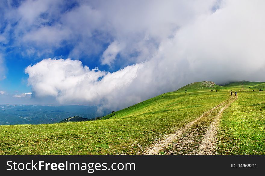 Panorama of the hill with road and big cloud.