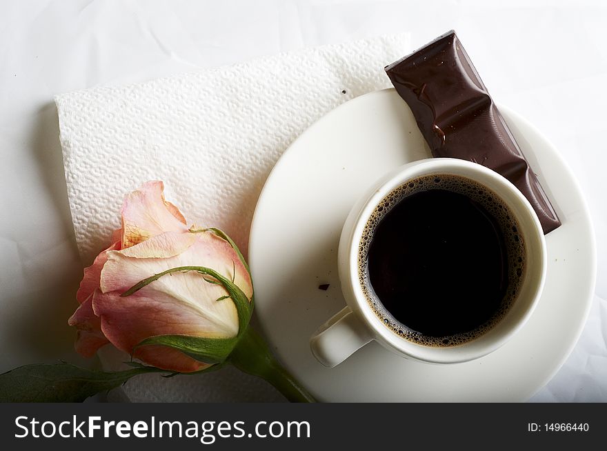 Cup of coffee with chocolate and rose