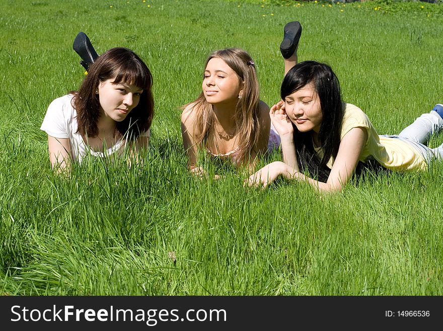 Three girls lying on grass