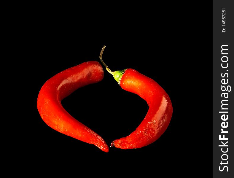Two pods of red pepper on black background