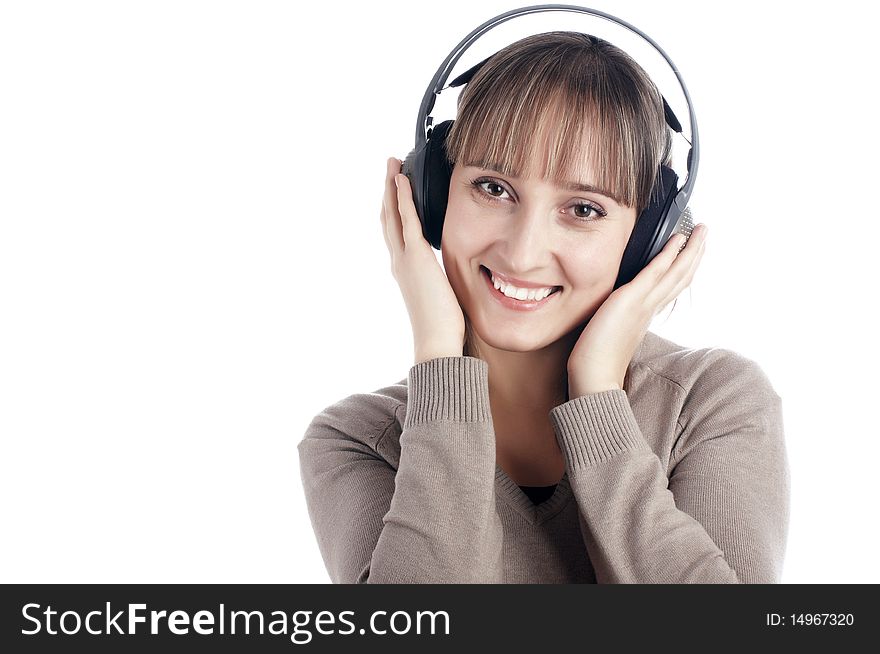 The young charming smiling girl listens to music in ear-phones