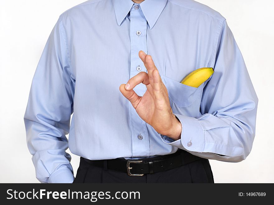 Man in the suit with the banana into pockets on the white background. Man in the suit with the banana into pockets on the white background