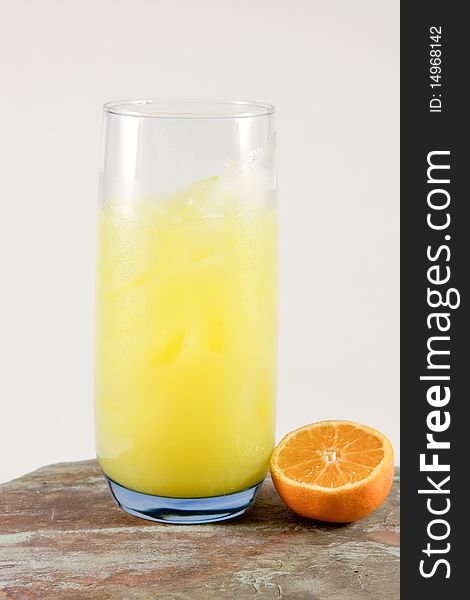 One half of orange and glass of orange juice. One half of orange and glass of orange juice.