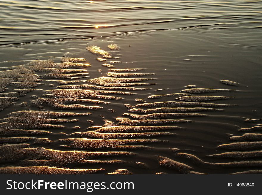 Sand ripples on beach with reflection of sunset. Sand ripples on beach with reflection of sunset