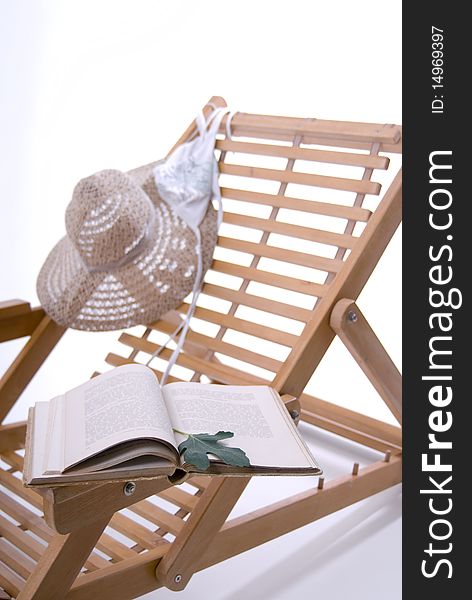 Beach chair, hat, book and a bikini top on a white background. Beach chair, hat, book and a bikini top on a white background.