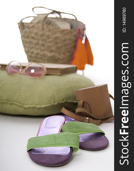 Flip-flops, an old camera, beach bag, sunglasses, book and a  bikini top, arranged on a white background. Flip-flops, an old camera, beach bag, sunglasses, book and a  bikini top, arranged on a white background.