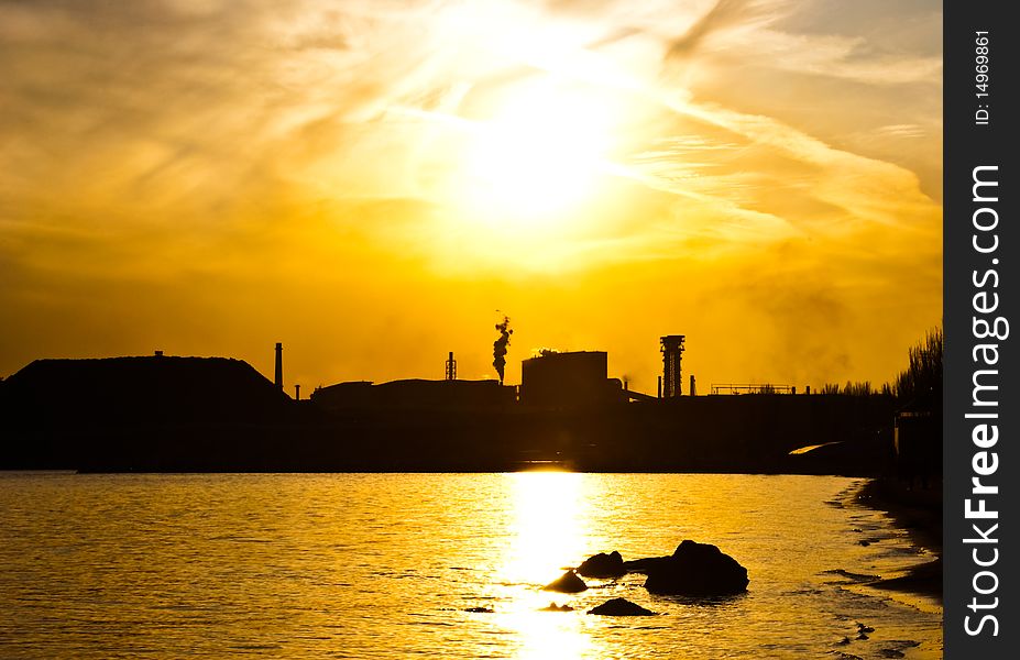 Metallurgical works- pipes and a smoke against the sunset sky