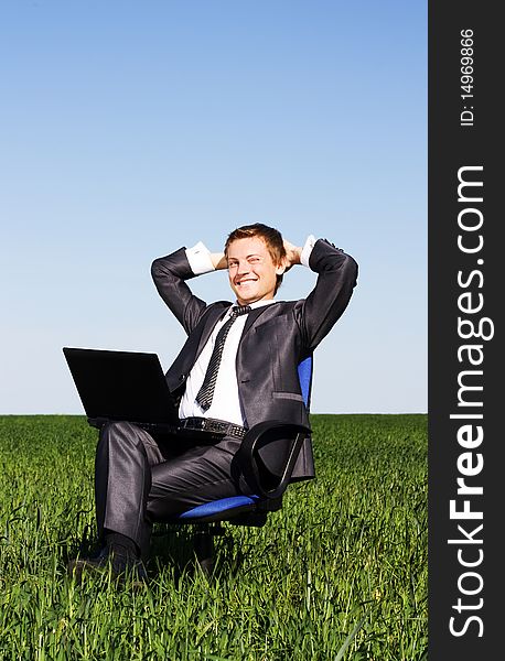 Young businessman on a green field. Young businessman on a green field