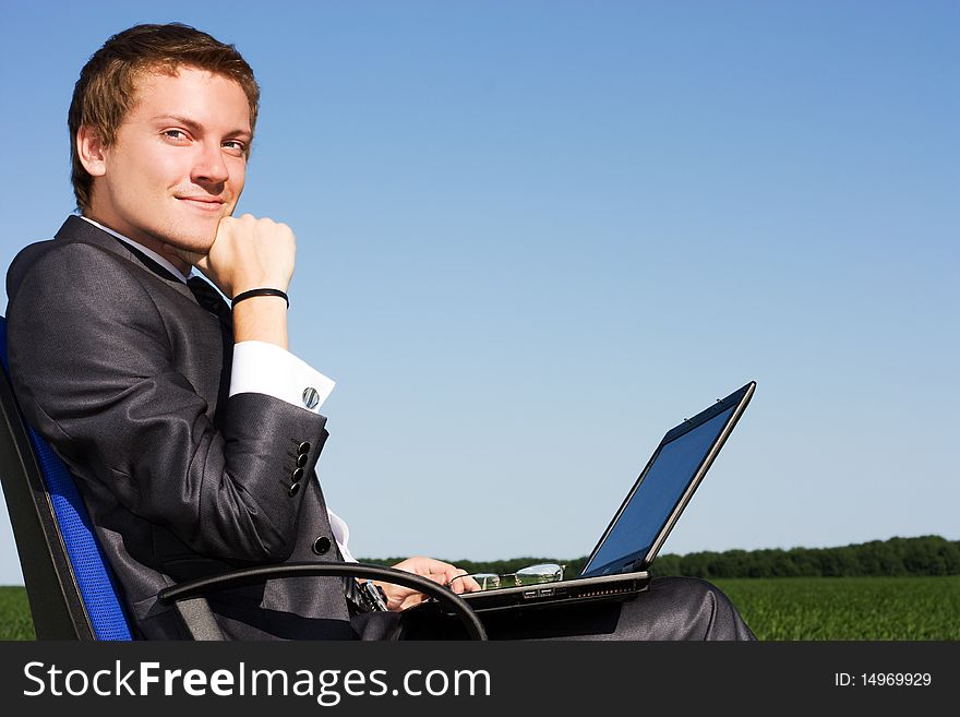 Businessman In The Field, With A Laptop