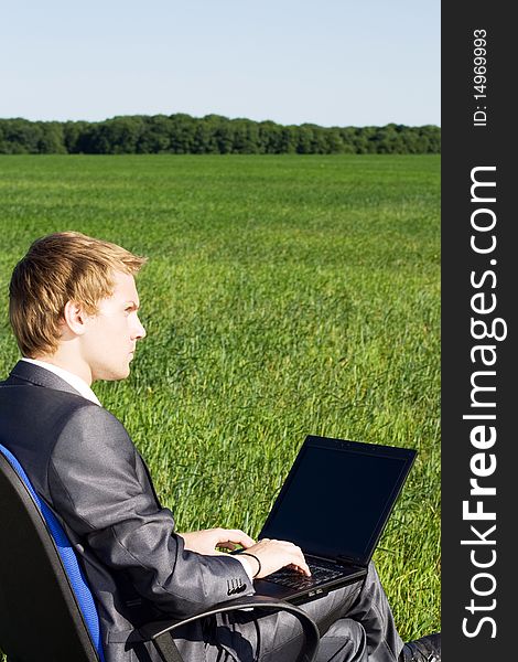 Businessman in the field, with a laptop