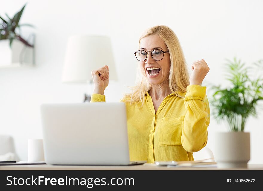 Happy Successful Businesswoman Triumphing With Laptop, Celebrating Victory In Office. Happy Successful Businesswoman Triumphing With Laptop, Celebrating Victory In Office