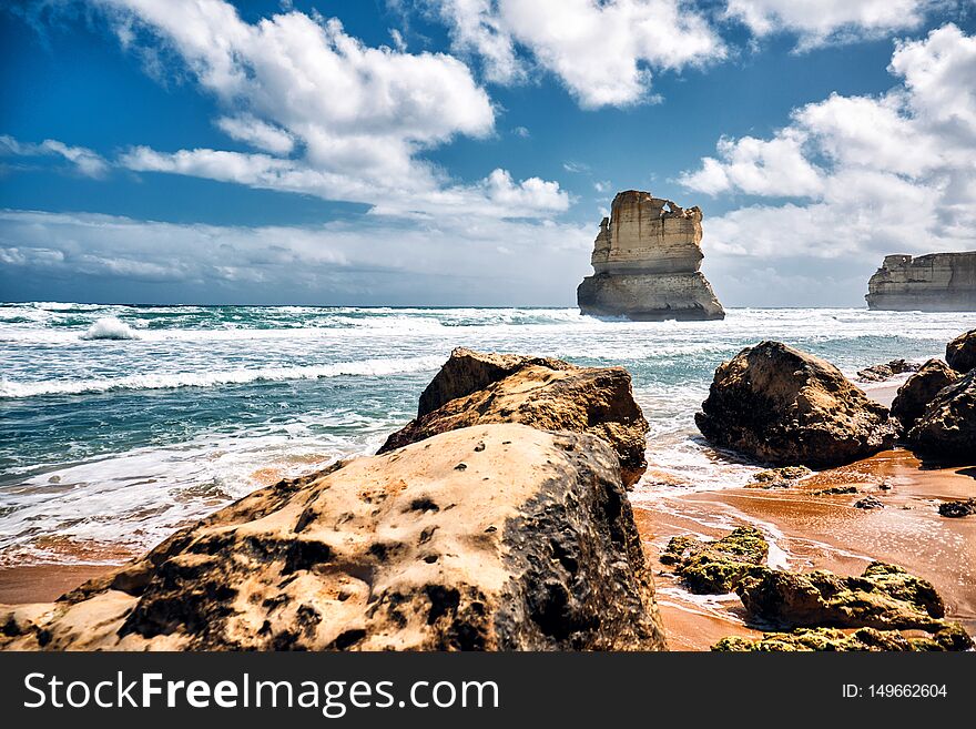 Famous touristic 12 Apostles scenic view from Gibson Steps, Australia in Victoria state on a clear day with rough sea near. Famous touristic 12 Apostles scenic view from Gibson Steps, Australia in Victoria state on a clear day with rough sea near