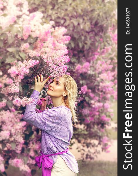 Beautiful blond woman in spring blooming lilac garden. Beautiful blond woman in spring blooming lilac garden