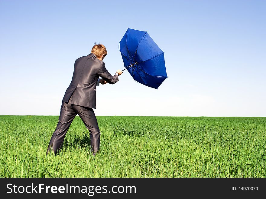 Businessman Holding An Umbrella In A Storm.