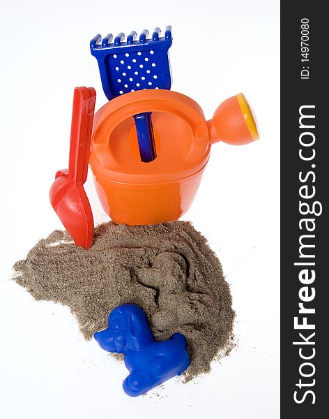 Sand play set - bucket, shovel, rack, mold and a pile of sand, on a white background. Sand play set - bucket, shovel, rack, mold and a pile of sand, on a white background
