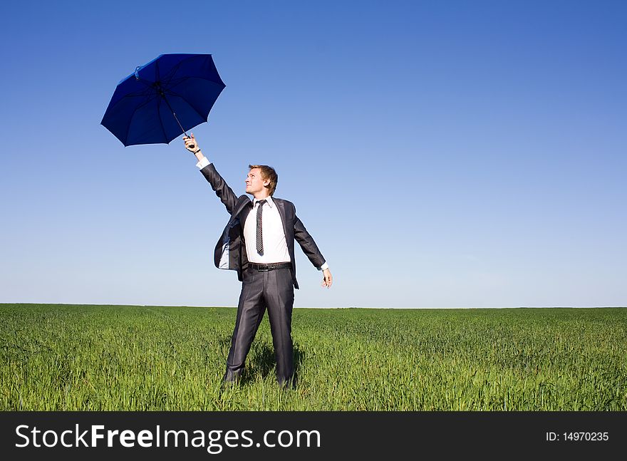 Businessman in the field carries a strong wind. Businessman in the field carries a strong wind