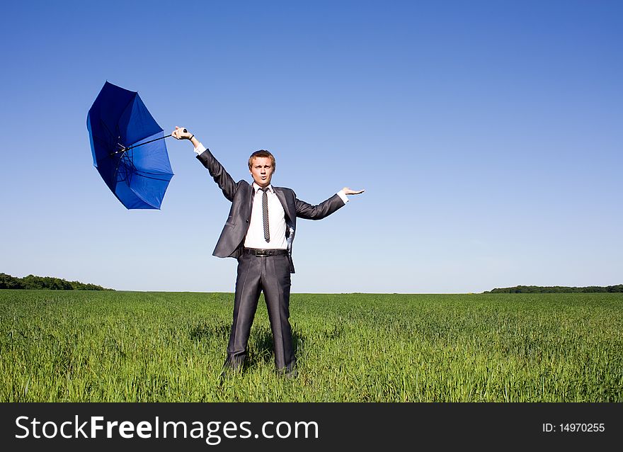 Businessman holding a umbrella at the field. Businessman holding a umbrella at the field