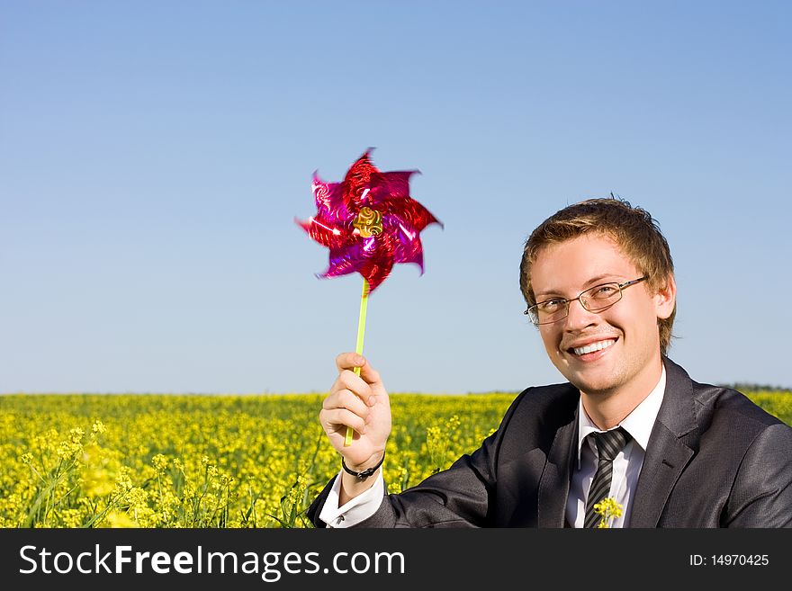 Well-dressed young businessman is resting in a field. Well-dressed young businessman is resting in a field