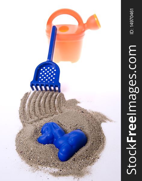 Sand play set - bucket, rack, mold and a pile of sand, on a white background. Sand play set - bucket, rack, mold and a pile of sand, on a white background