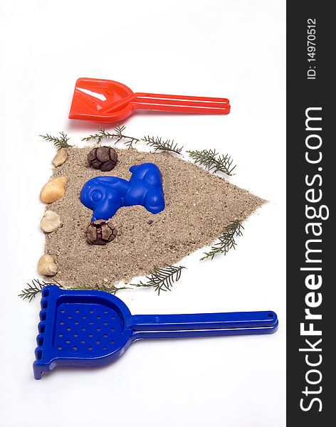 Sand play set -  shovel, rack, mold and a pile of sand, in a shape of seal, on a white background. Sand play set -  shovel, rack, mold and a pile of sand, in a shape of seal, on a white background