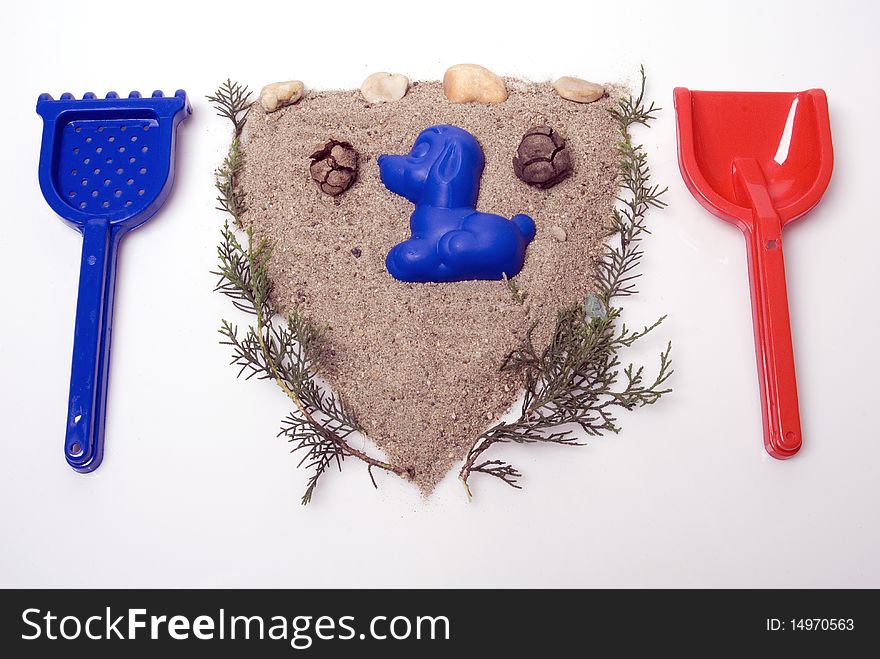 Sand play set -  shovel, rack, mold and a pile of sand, in a shape of seal, on a white background. Sand play set -  shovel, rack, mold and a pile of sand, in a shape of seal, on a white background