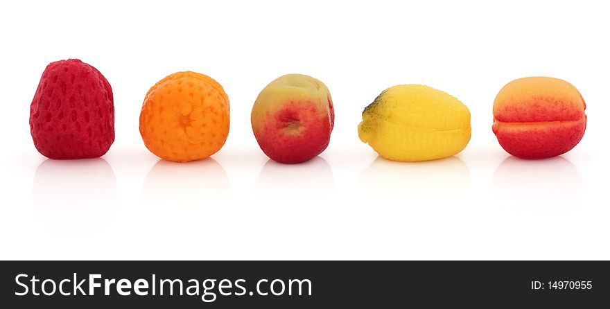 Marzipan fruit sweets, strawberry, orange, apple, lemon and plum, isolated over white background.