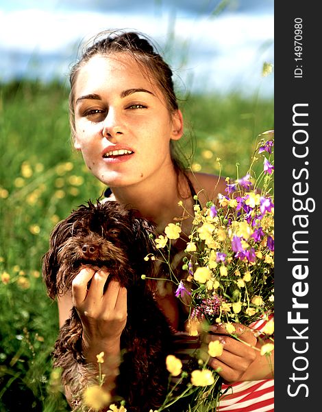 Portrait of a beautiful girl with dog in a field