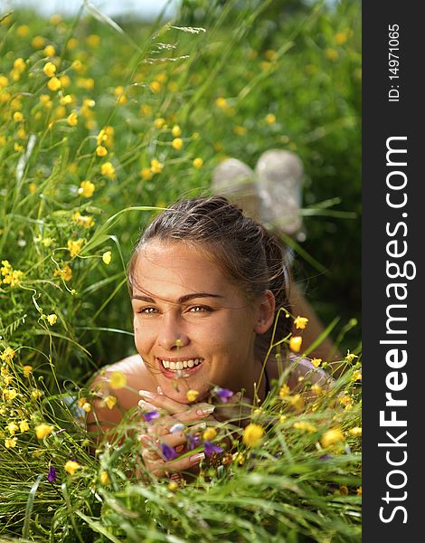 Beautiful girl lays on a meadow with flowers, summer. Beautiful girl lays on a meadow with flowers, summer