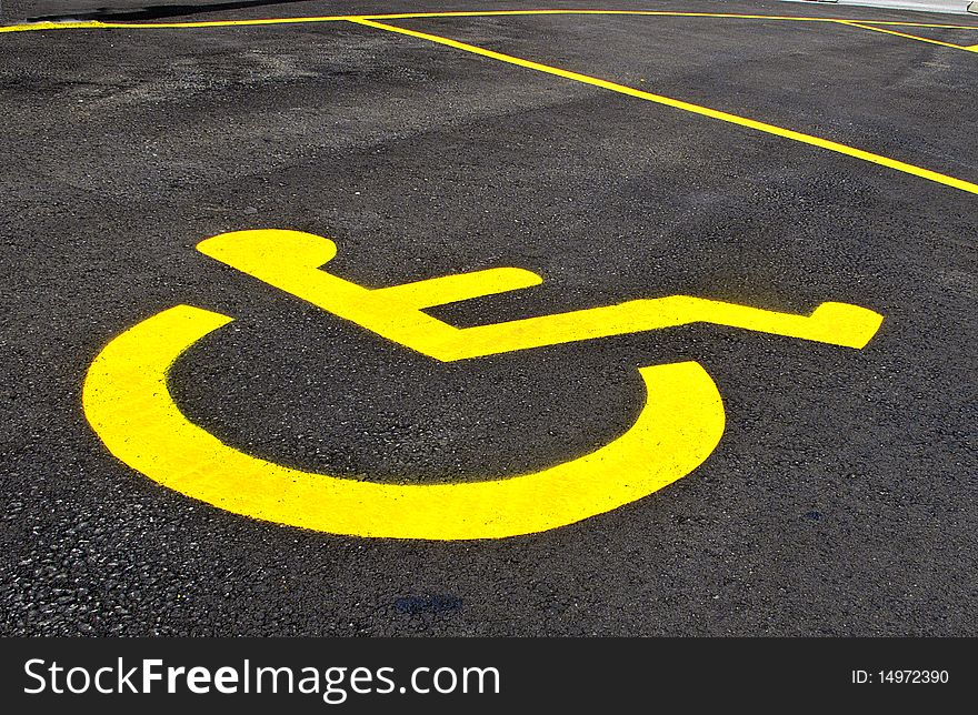 Yellow symbol for designated parking spot for handicapped driver. Yellow symbol for designated parking spot for handicapped driver