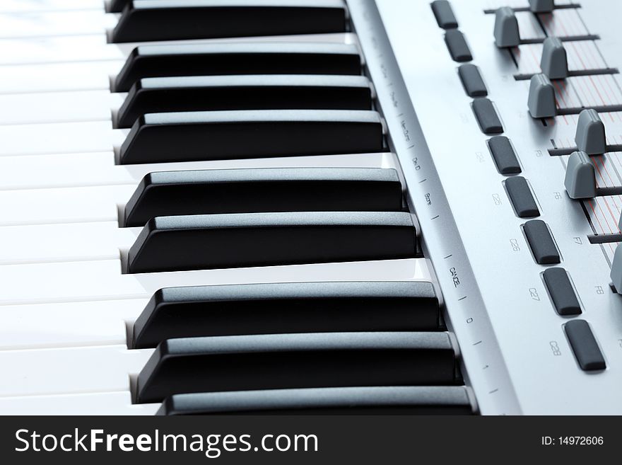 Closeup of the keys and faders on a MIDI controller keyboard. Closeup of the keys and faders on a MIDI controller keyboard