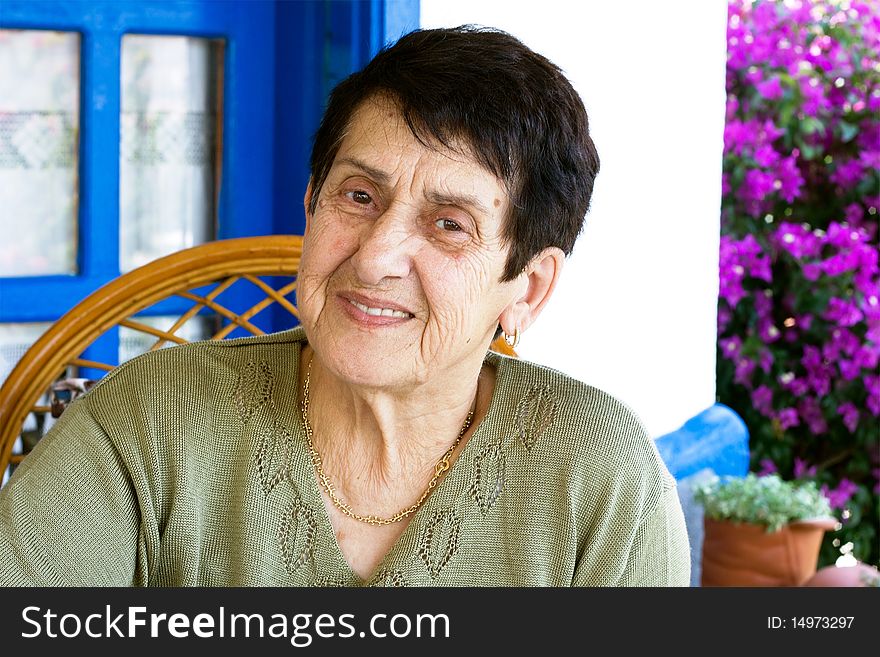 Senior retired woman sitting in her garden. Senior retired woman sitting in her garden