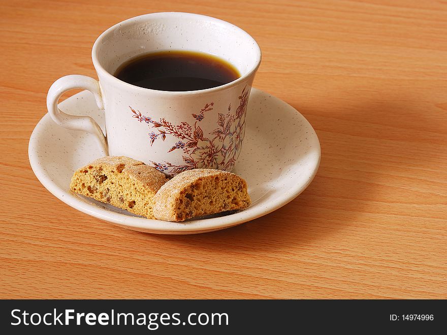 A mug of coffee with biscuits