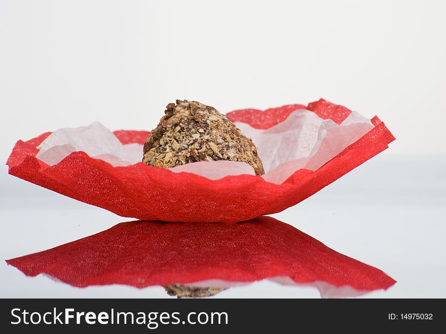 Delicious covered chocolate truffle  on reflective surface