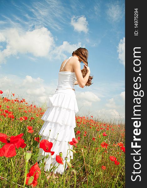 Beautiful young woman posing in the field of poppies. Beautiful young woman posing in the field of poppies