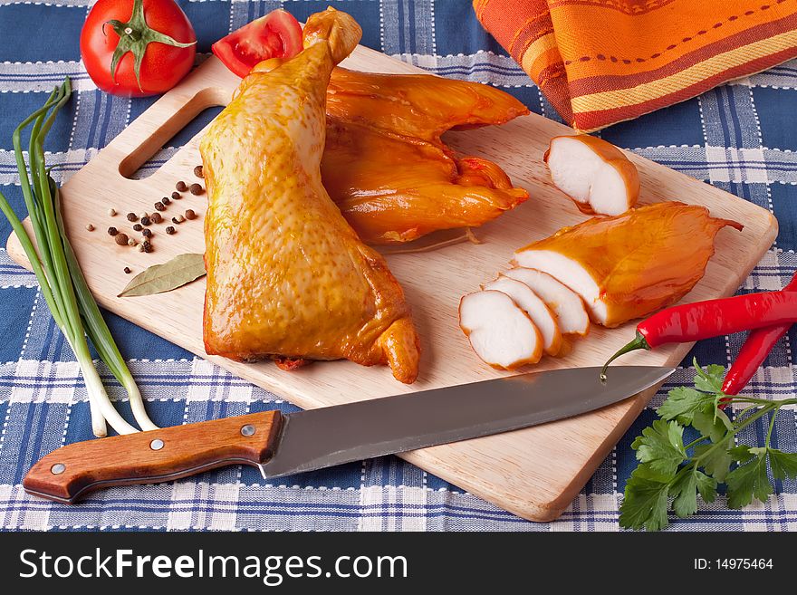 Meat smoked chicken on a wooden cutting board.