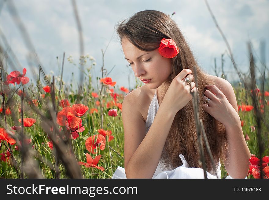 Beautiful young woman posing in the field of poppies. Beautiful young woman posing in the field of poppies