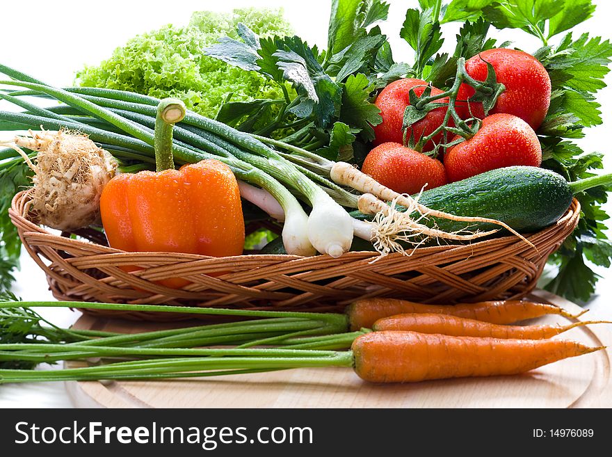 Organic vegetables in basket on white background