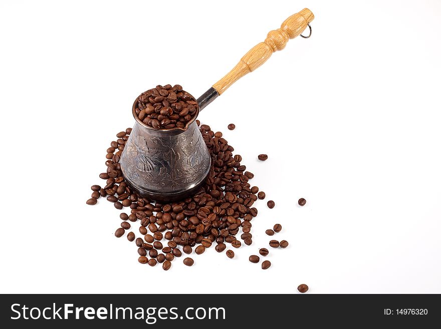 Coffee grains poured out in a coffee pot on a white background. The top view